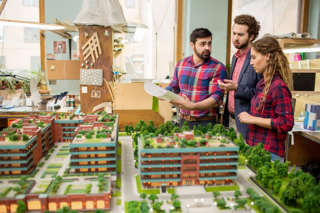 Group of young architects discussing new blocks of flats and other places of the city at meeting